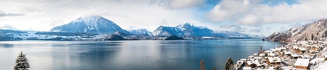 Imagem de lago com montanhas ao fundo.